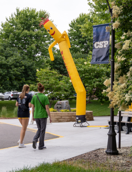 A student and a parent walking toward a college campus