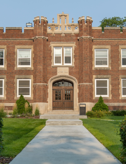 Historic brown and tan brick residence hall building on a college campus.