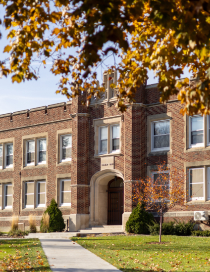 Brown and tan historic brick building on a college campus.